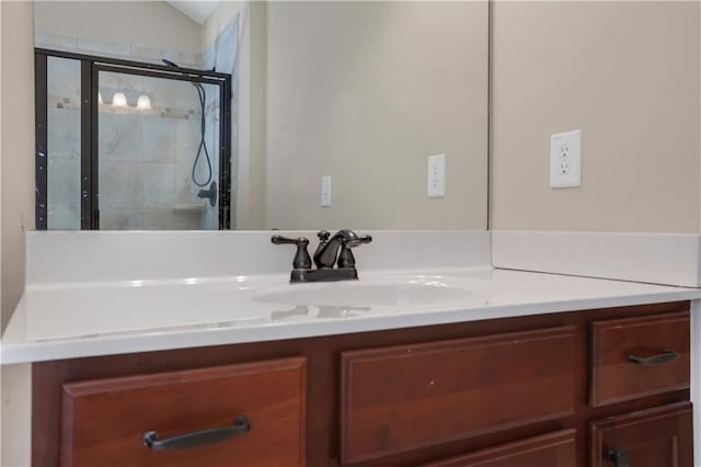 bathroom featuring vanity, a shower with door, and lofted ceiling