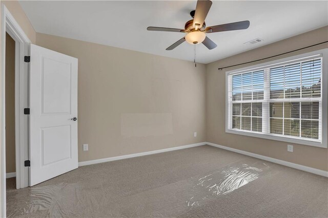 unfurnished room featuring light carpet and ceiling fan