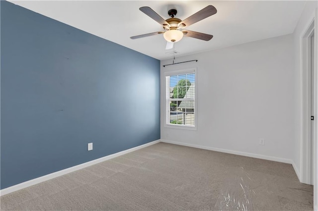 carpeted spare room featuring ceiling fan