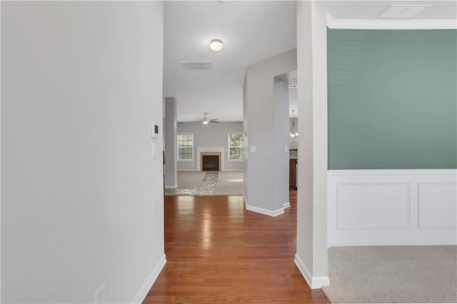 corridor featuring wood-type flooring and crown molding