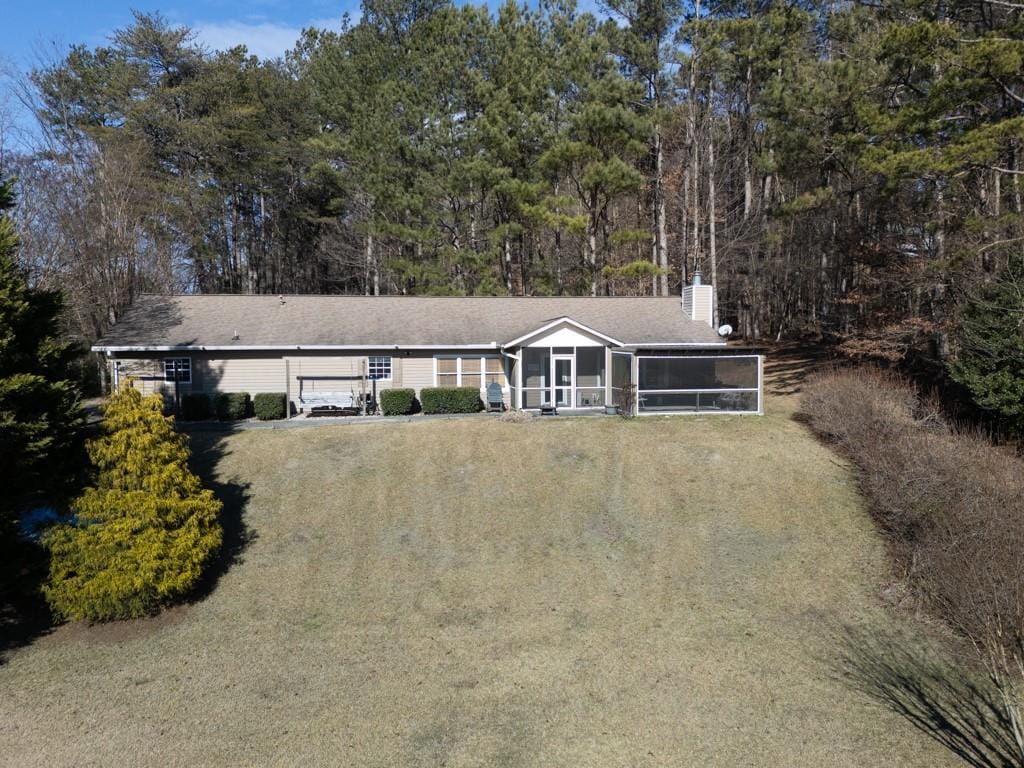 ranch-style home with a front lawn and a sunroom