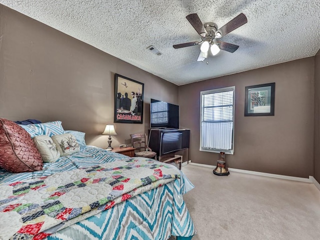 carpeted bedroom featuring a textured ceiling and ceiling fan