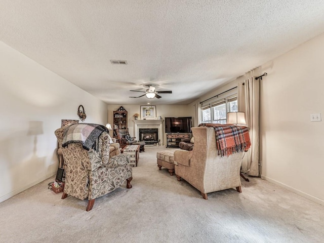 carpeted living room featuring a textured ceiling and ceiling fan