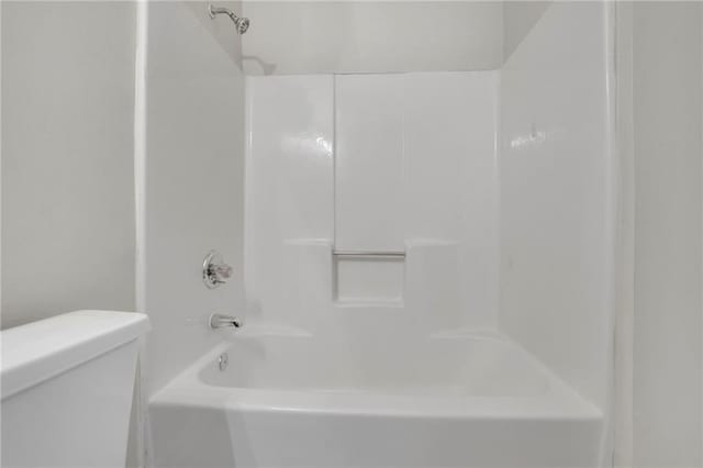 bathroom featuring shower / washtub combination and toilet