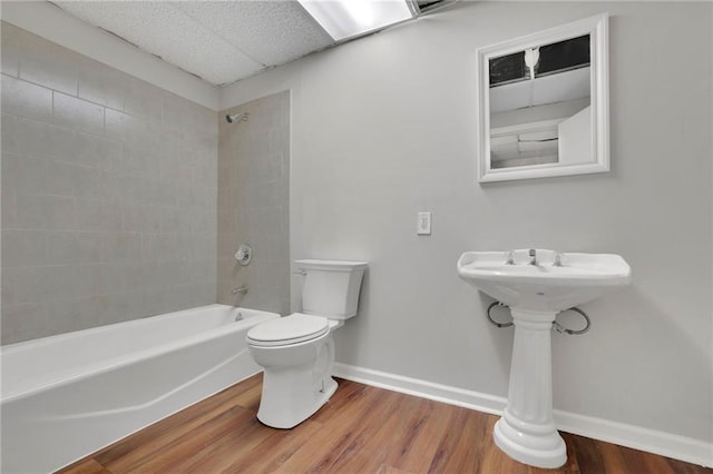 bathroom featuring tiled shower / bath combo, toilet, and hardwood / wood-style flooring