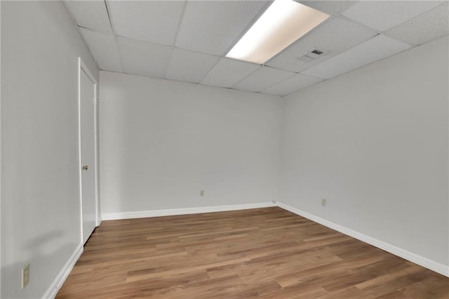 empty room featuring wood-type flooring and a paneled ceiling