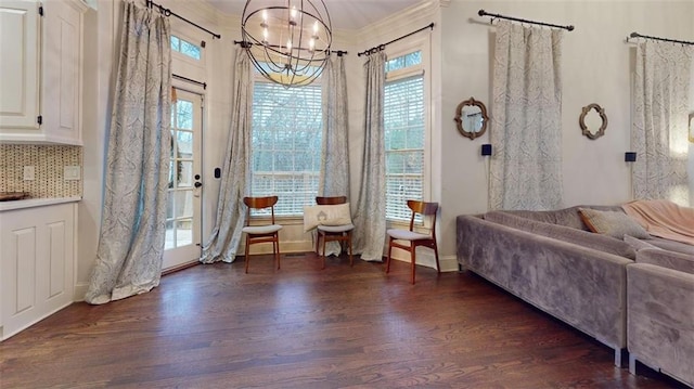 living room with dark hardwood / wood-style floors, a healthy amount of sunlight, and a chandelier