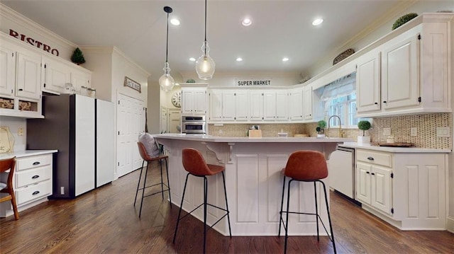 kitchen featuring appliances with stainless steel finishes, tasteful backsplash, white cabinets, a center island, and dark wood-type flooring