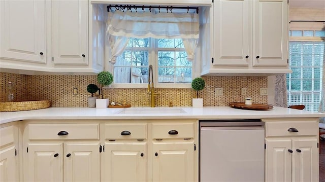 kitchen with decorative backsplash, dishwasher, sink, and a wealth of natural light