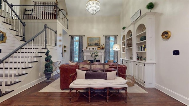 living room with a notable chandelier, hardwood / wood-style floors, and a high ceiling