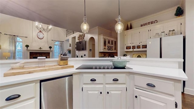 kitchen featuring white refrigerator, hanging light fixtures, crown molding, white cabinetry, and dark hardwood / wood-style flooring