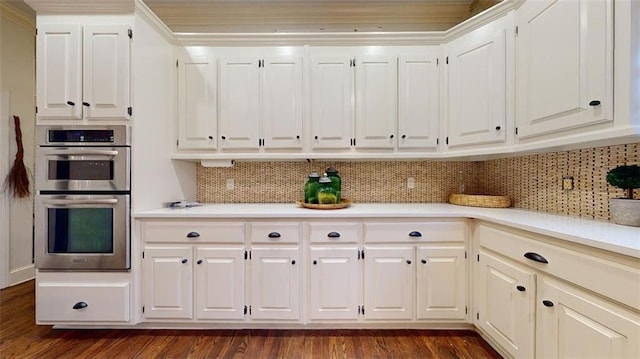 kitchen with white cabinets, dark wood-type flooring, backsplash, and stainless steel double oven