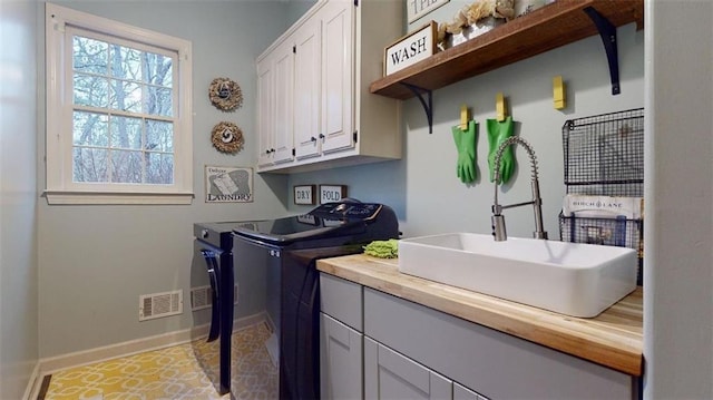 laundry area featuring sink, cabinets, washer and dryer, and light tile patterned floors