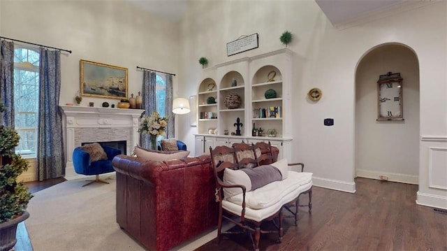 living room featuring built in features, a healthy amount of sunlight, and hardwood / wood-style floors