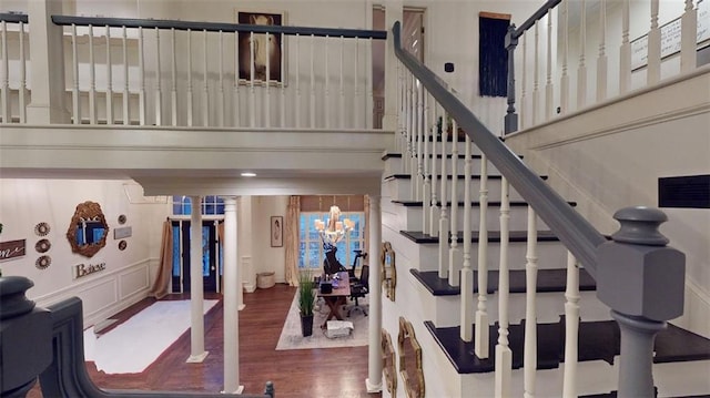 staircase featuring wood-type flooring and a chandelier