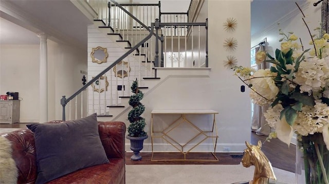 staircase with wood-type flooring, decorative columns, and crown molding