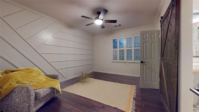 interior space with crown molding, dark hardwood / wood-style flooring, a barn door, and ceiling fan