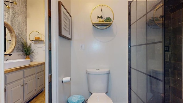 bathroom featuring a shower with shower door, toilet, and vanity