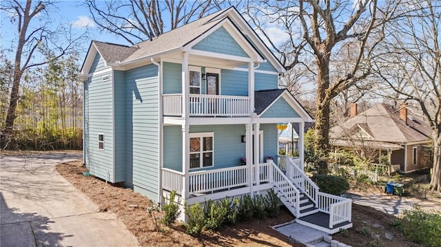 view of front of house with a balcony, a shingled roof, and a porch