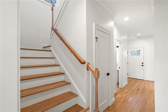 staircase with crown molding, baseboards, hardwood / wood-style flooring, and recessed lighting