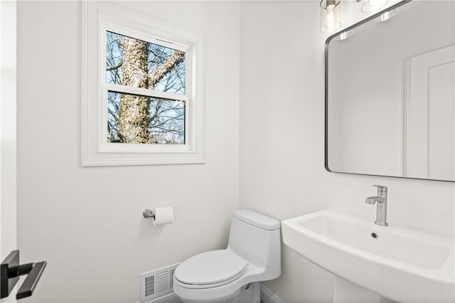 bathroom with visible vents, a sink, and toilet