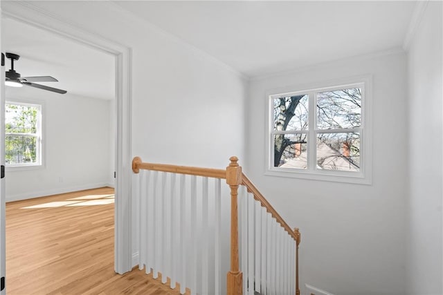 stairs with ceiling fan, baseboards, crown molding, and wood finished floors