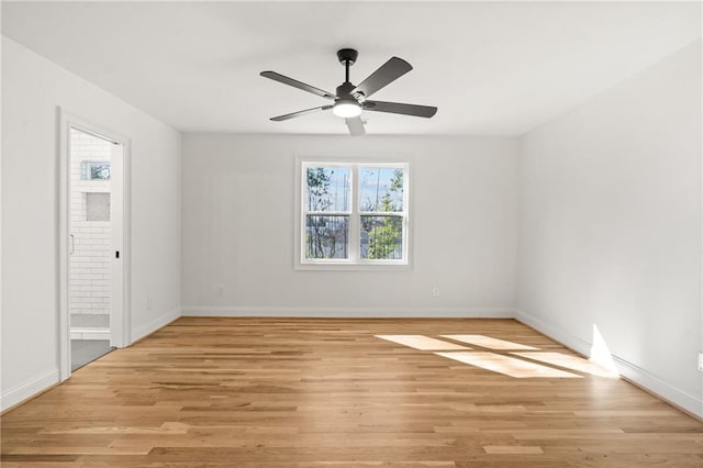 unfurnished room with light wood-type flooring, ceiling fan, and baseboards