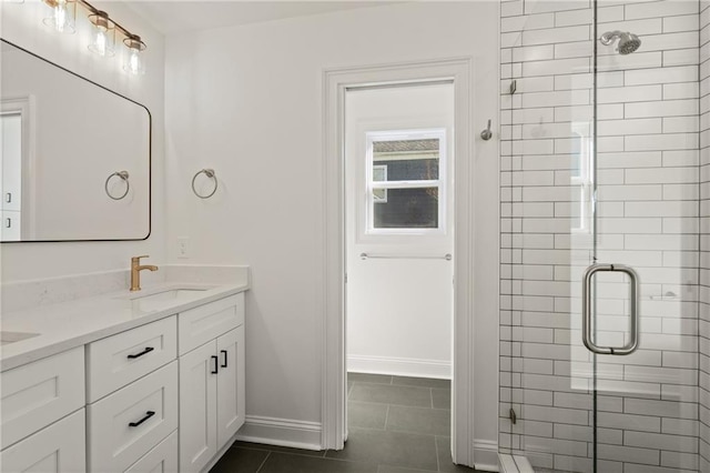 full bath with a stall shower, double vanity, a sink, and tile patterned floors