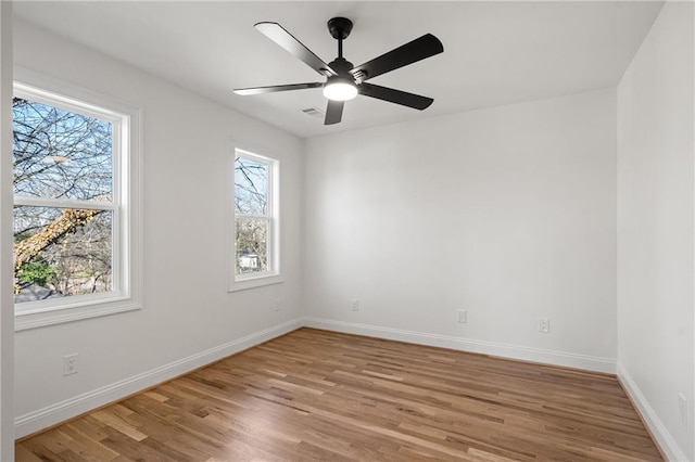 empty room with light wood-type flooring, ceiling fan, and baseboards