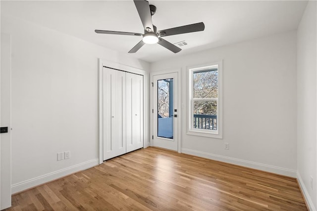 unfurnished bedroom featuring access to exterior, visible vents, baseboards, and wood finished floors