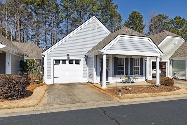 view of front of property with concrete driveway, an attached garage, a porch, and a shingled roof