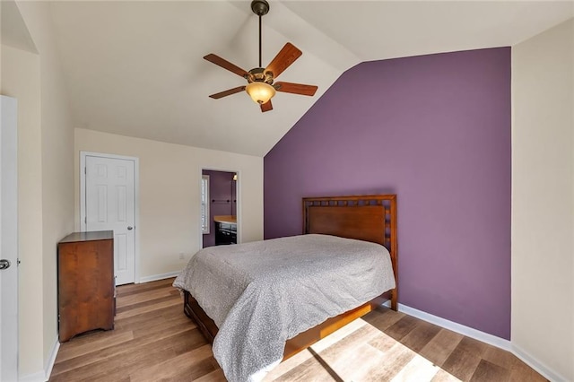 bedroom with ceiling fan, baseboards, lofted ceiling, and wood finished floors