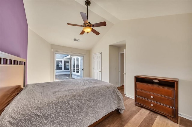 bedroom featuring a ceiling fan, wood finished floors, visible vents, baseboards, and vaulted ceiling