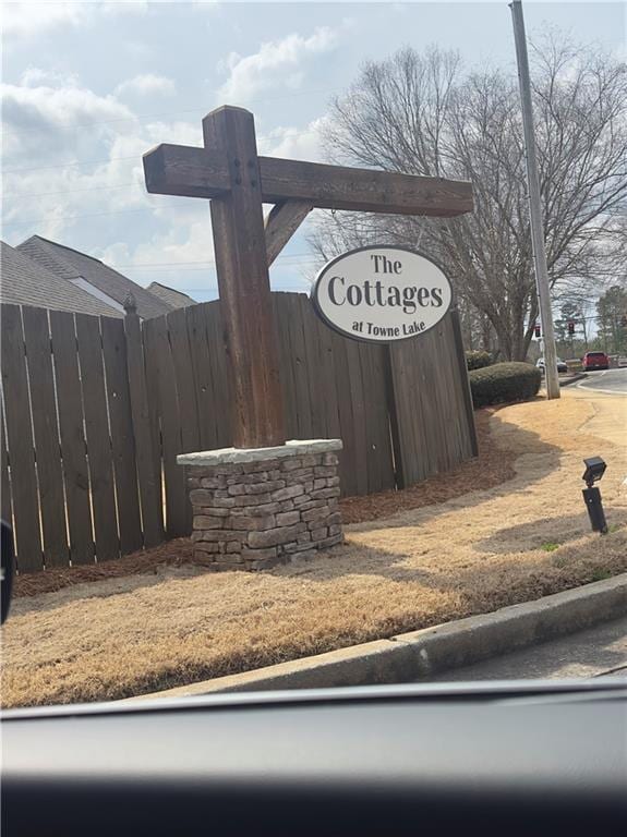 community / neighborhood sign featuring fence