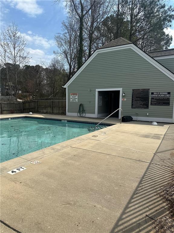 pool featuring fence and a patio area