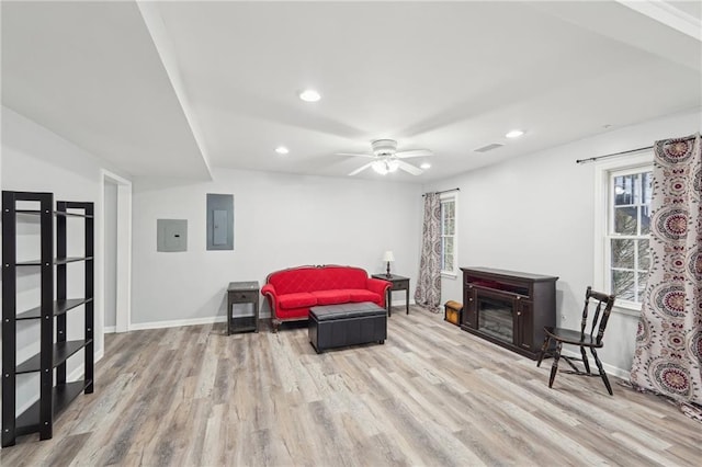 sitting room featuring recessed lighting, a fireplace, baseboards, light wood-type flooring, and electric panel