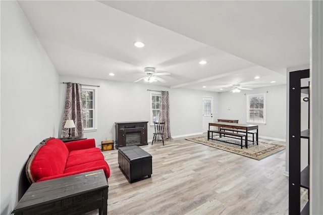 living room with light wood finished floors, baseboards, and recessed lighting