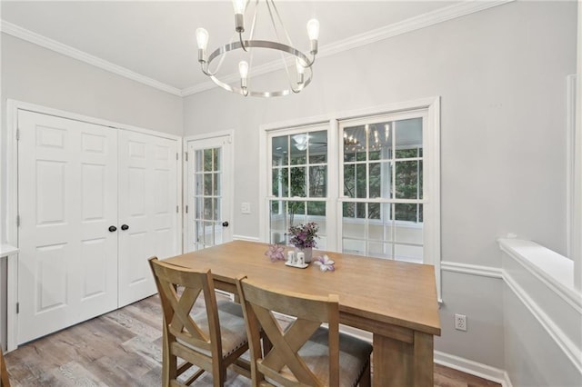 dining room featuring an inviting chandelier, crown molding, and wood finished floors