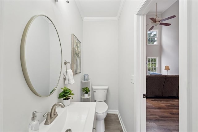 half bathroom with baseboards, toilet, ensuite bath, ornamental molding, and wood finished floors