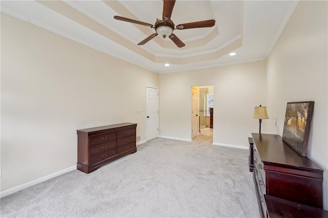 unfurnished bedroom with recessed lighting, light colored carpet, baseboards, ornamental molding, and a raised ceiling