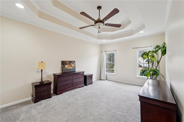 bedroom featuring ornamental molding, a raised ceiling, light carpet, and baseboards