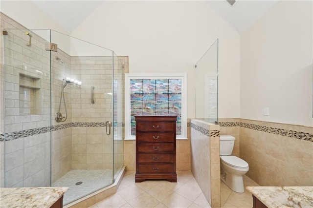 bathroom featuring toilet, a stall shower, vaulted ceiling, vanity, and tile patterned floors