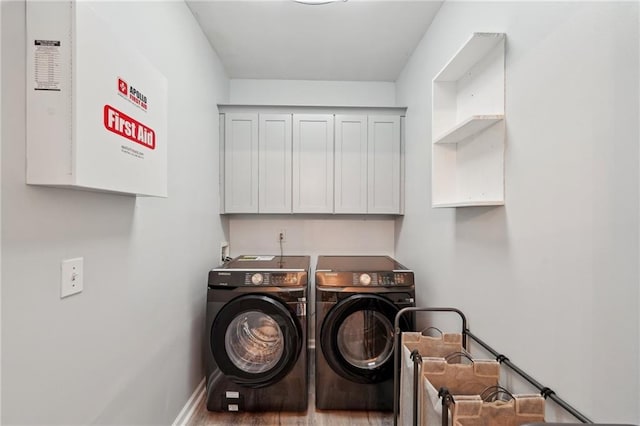 washroom featuring cabinet space, baseboards, and washing machine and clothes dryer