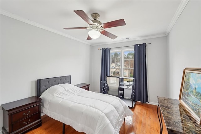 bedroom with crown molding, a ceiling fan, visible vents, and light wood-style floors