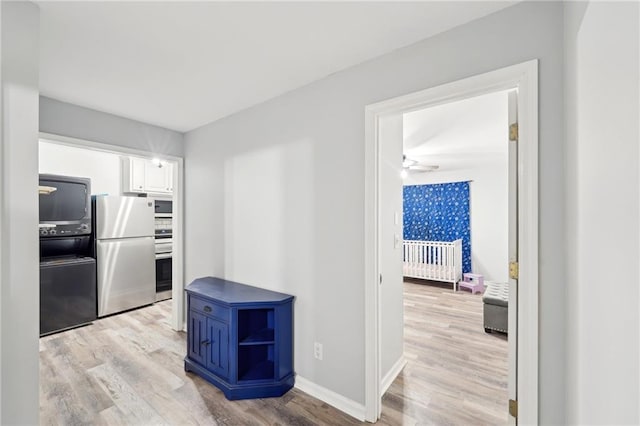 kitchen featuring stainless steel appliances, white cabinetry, light wood-style flooring, and open shelves