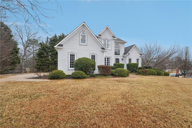 traditional-style home featuring a front lawn and stucco siding