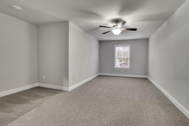 carpeted empty room with a ceiling fan and baseboards