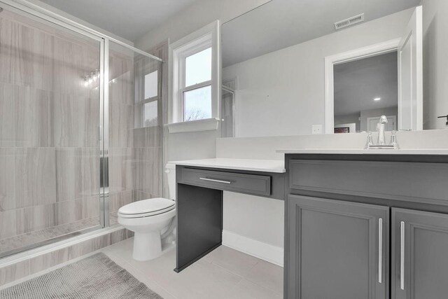 bathroom with visible vents, a stall shower, toilet, and vanity
