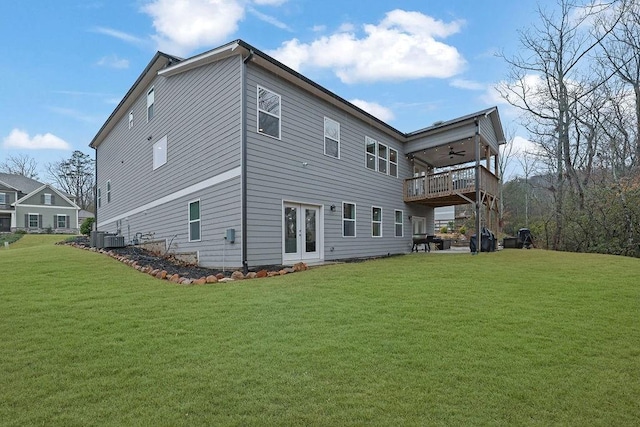 back of property with a yard, central air condition unit, ceiling fan, and french doors