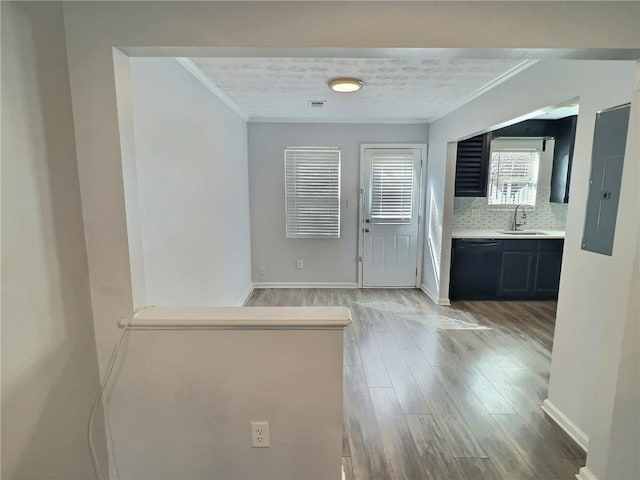 kitchen with dishwasher, wood-type flooring, sink, and crown molding